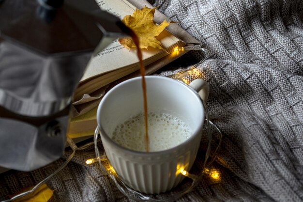 Café chaud à la crème sur un plaid tricoté