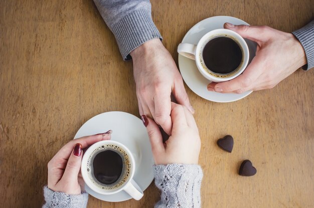 Café chaud dans les mains. Boissons Mise au point sélective.