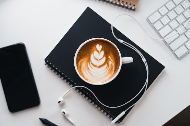 Café chaud dans une tasse au bureau d'ordinateur