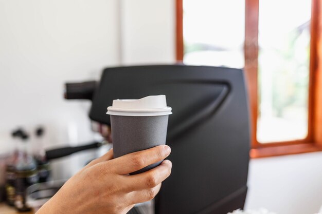 Café chaud dans une tasse de papier dans la main d'un barista