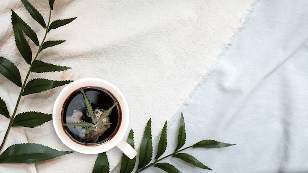 café chaud avec feuille de cannabis sur la table