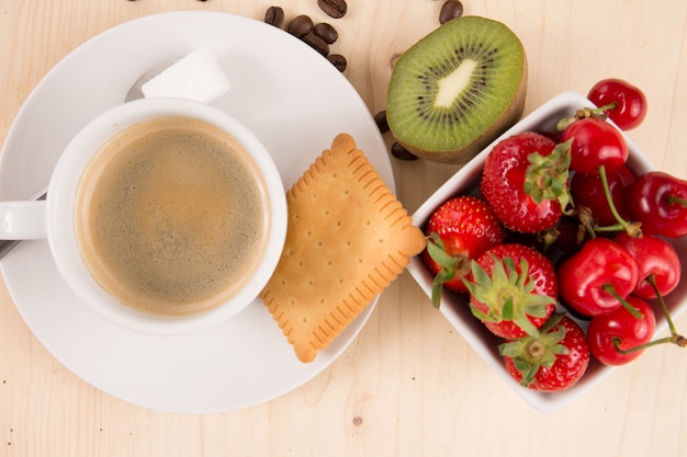 Café chaud, gâteau et fruits sur une table en bois