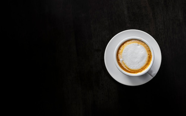 Photo café chaud et haricots sur une table en bois noir à l'arrière-plan vue supérieure