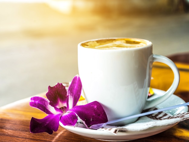 Café chaud avec le lever du soleil, tasse de café avec fleur.