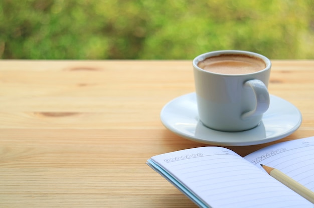 Café chaud avec des notes sur la table en bois