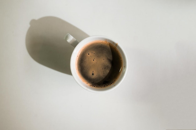 Café chaud sur une table avec de la crème qui y est versée montrant la texture