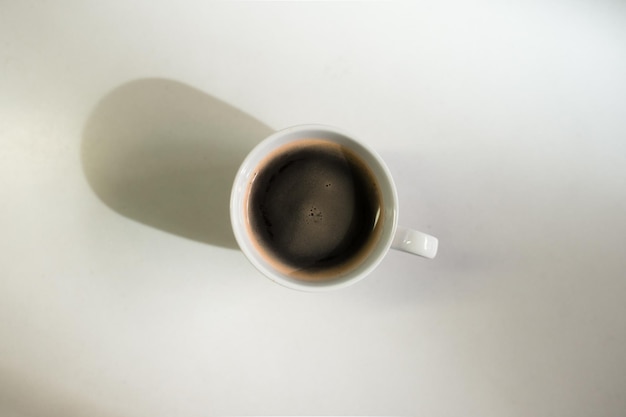 Café chaud sur une table avec de la crème qui y est versée montrant la texture