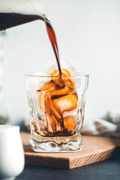 Le café coule avec un verre avec des glaçons