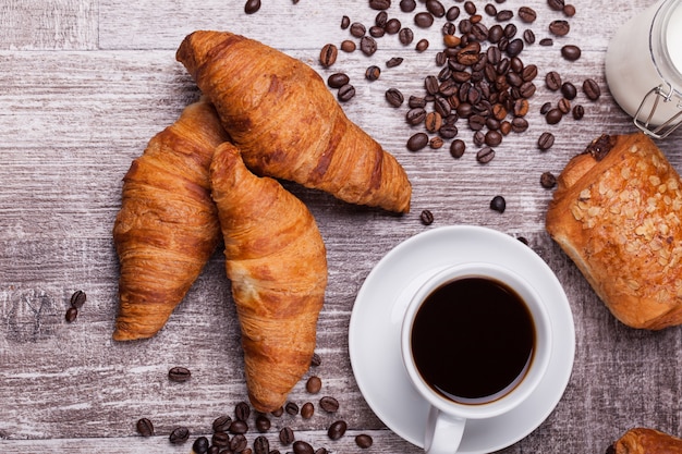 Café et croissant au beurre fraîchement cuit sur une table en bois vintage. Brunch délicieux.