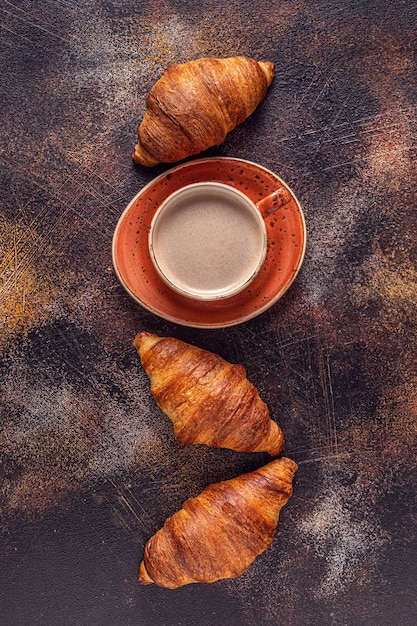 Café et croissant sur fond de pierre. Petit déjeuner français. Vue de dessus avec espace de copie.