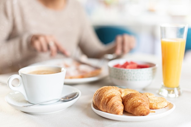 Café et croissant pour le petit déjeuner dans une table.