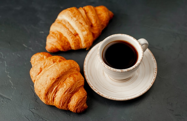 Café et croissant sur une table en pierre. petit déjeuner le matin, avec copie espace pour le texte