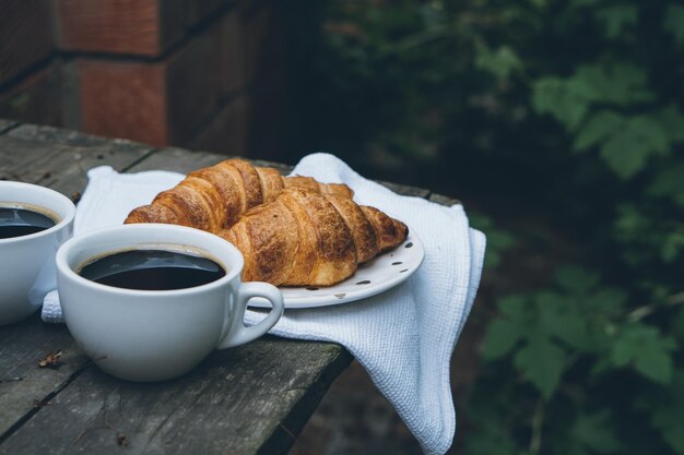 Café et croissants sur une vieille table en bois rustique