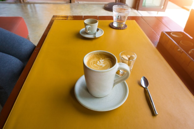 Café Cuplatte sur une table en cuir jaune