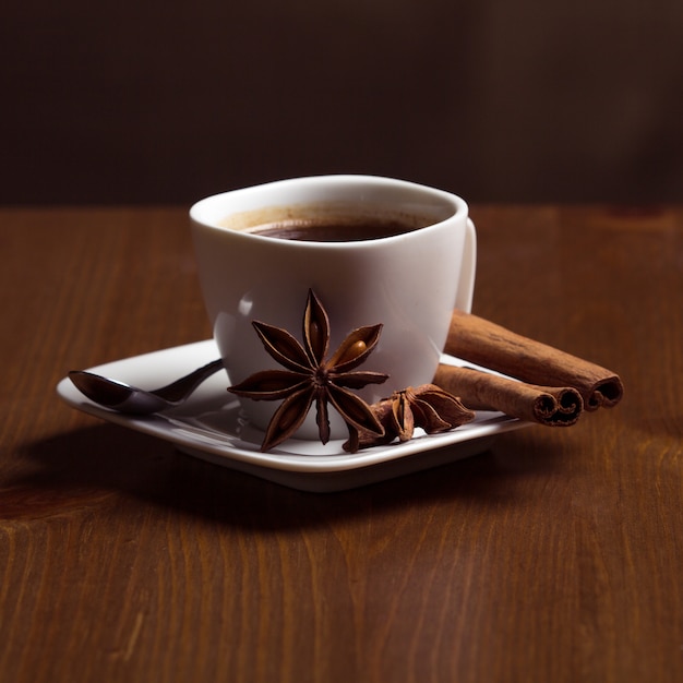 Café Dans Une Tasse Blanche à La Cannelle Sur Une Table En Bois