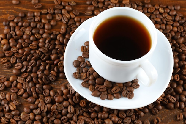 Café dans une tasse blanche et grains de café