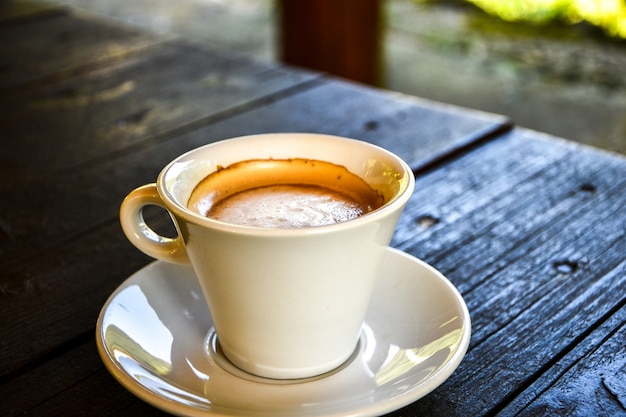 Café dans une tasse blanche sur une table en bois sombre au café. Café