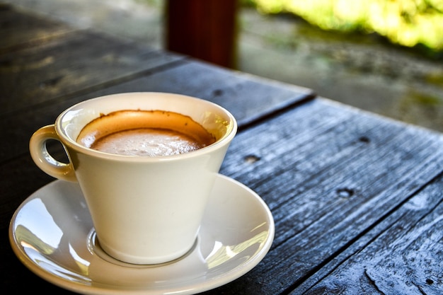 Café dans une tasse blanche sur une table en bois sombre au café. Café