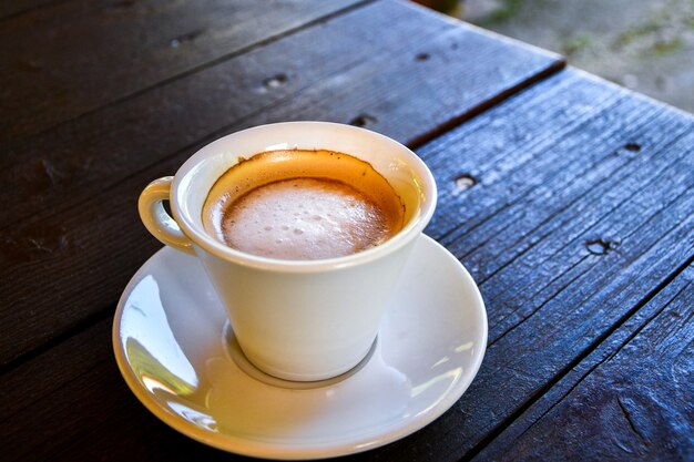 Café dans une tasse blanche sur une table en bois sombre au café. Café