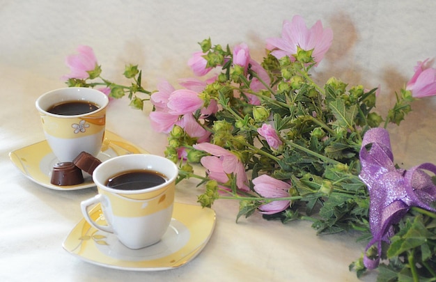 Café dans une tasse, bonbons, fleurs et coffret cadeau