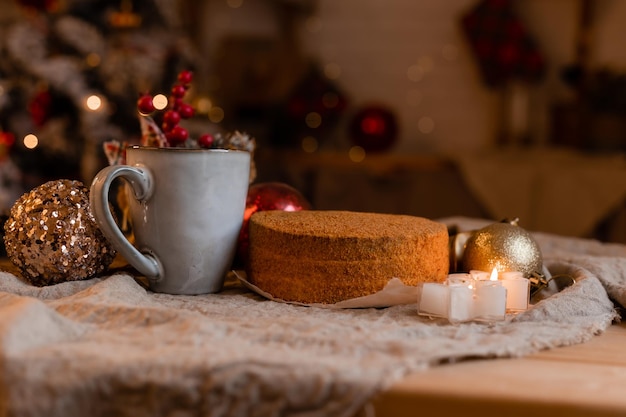 café dans une tasse design et gâteau au miel fait maison sur une table en bois dans une ambiance Nouvel An