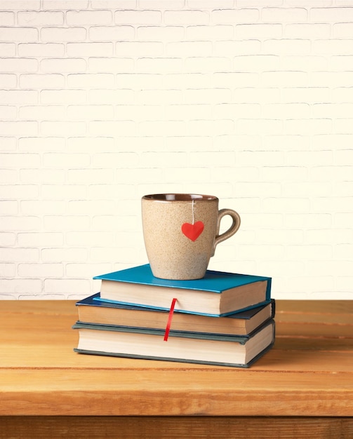 Café dans une tasse avec des livres sur fond flou