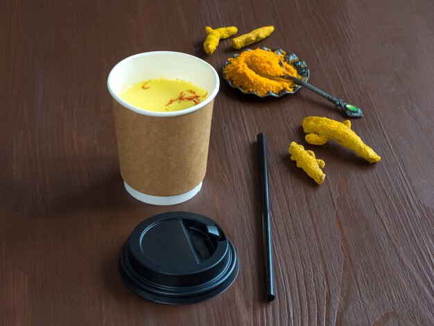 Café dans une tasse en papier avec du curcuma. Prévention des infections antivirales