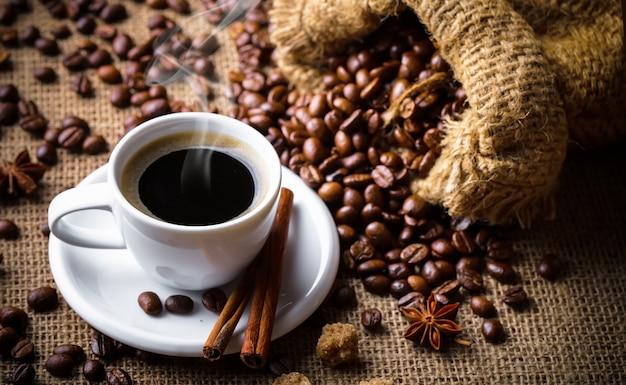 Café dans une tasse et une soucoupe sur fond de toile de jute