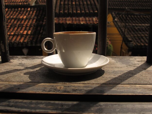 Café dans une tasse sur une table en bois dans un café avec un fond d'éclairage