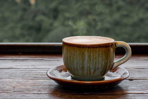 Photo café dans une tasse verte sur une table en bois au café