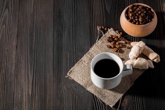 Café du matin dans une tasse blanche, cookies aux pépites de chocolat sur un fond en bois