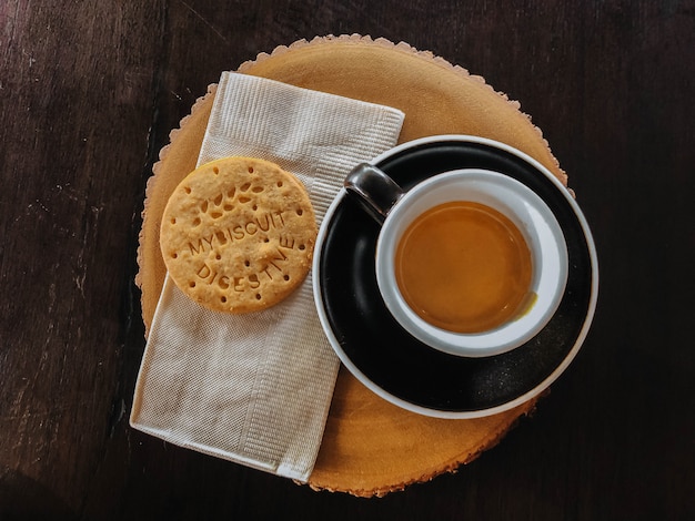 Café Du Matin Dans Une Tasse Noire Et Des Biscuits Sur Une Planche à Découper En Bois