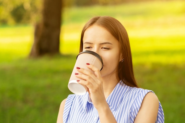 café à emporter jeune femme boit une boisson chaude le matin avant de travailler dans le parc