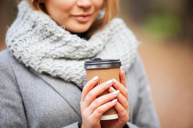 Café à emporter Jeune femme avec du café dans le parc en automne