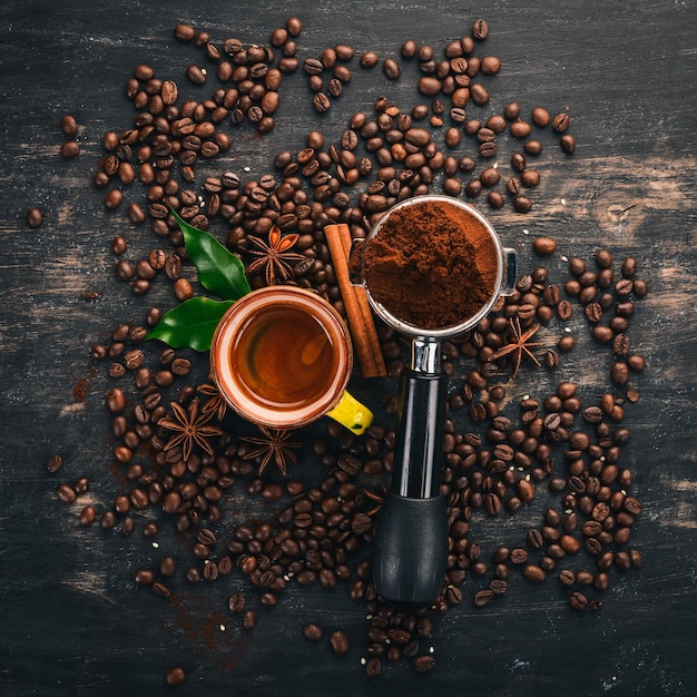 Café expresso chaud dans une tasse de cannelle sur un fond en bois noir Vue de dessus Espace de copie