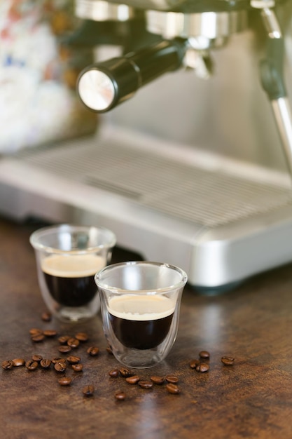 Café expresso doppio ou lungo dans une tasse transparente sur fond flou