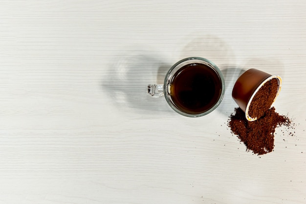 Café expresso sur fond blanc avec capsule ouverte. Vue de dessus.