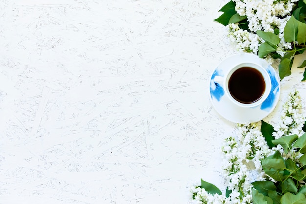 Café sur un fond en bois et des fleurs. Lilas. Printemps. Matin. 8 mars. Journée de la femme