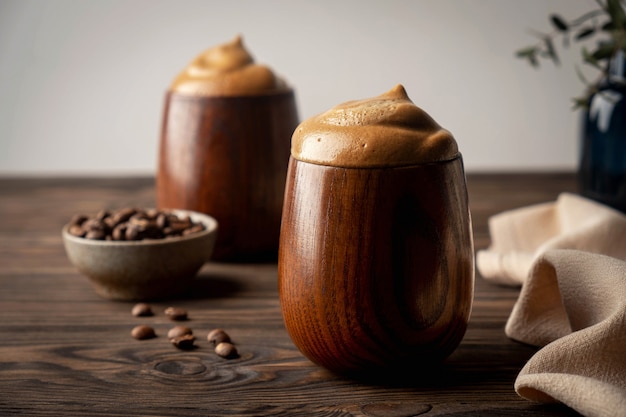 Café fouetté moelleux, café dalgona, verres en bois vintage avec une boisson, boisson coréenne tendance