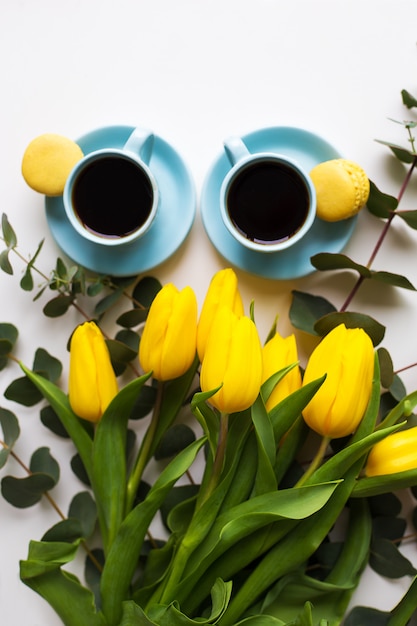Café fraîchement moulu, macarons et bouquet de tulipes jaunes