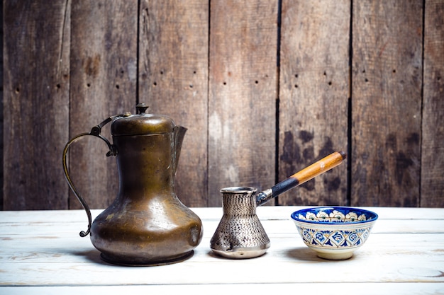 Café frais en cezve sur une table en bois