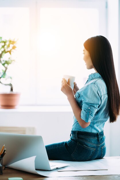 Le café frais fait sa journée. vue postérieure, de, jeune, femme asiatique, tenue, tasse café