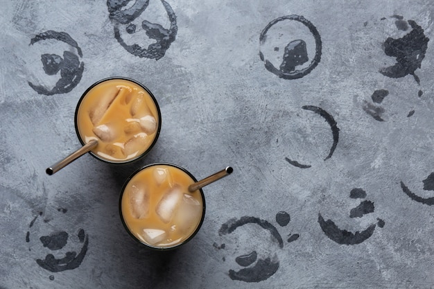 Photo café froid avec du lait et de la glace sur un espace gris avec des traces humides de verres