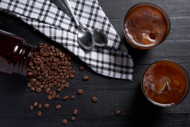 café froid sur une table sombre avec des grains de café