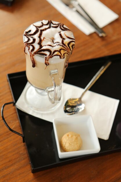 Café glacé au lait. Café au lait glacé. Femme tenant une tasse de café glacé en verre.