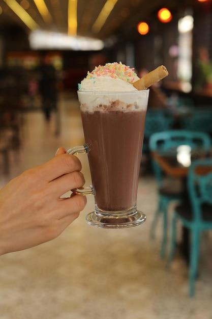 Café glacé au lait. Café au lait glacé. Femme tenant une tasse de café glacé en verre.