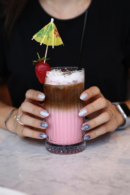 Café glacé au lait Café latte glacé Femme tenant une tasse en verre de café glacé