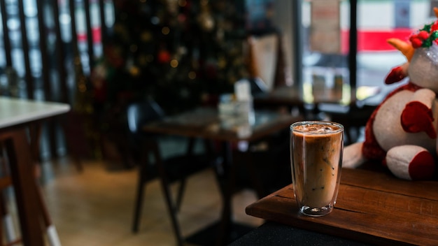 Café glacé au lait servi sur la table noire dans un café fond de vacances de noël