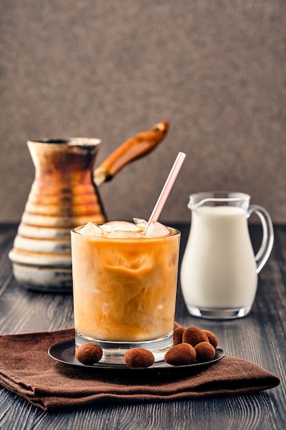 Café glacé à la crème sur un mur en bois foncé