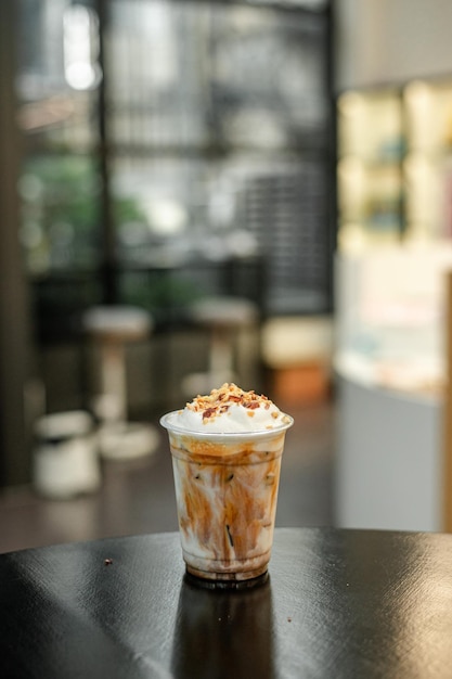 café glacé dans du verre en plastique sur une table noire au café